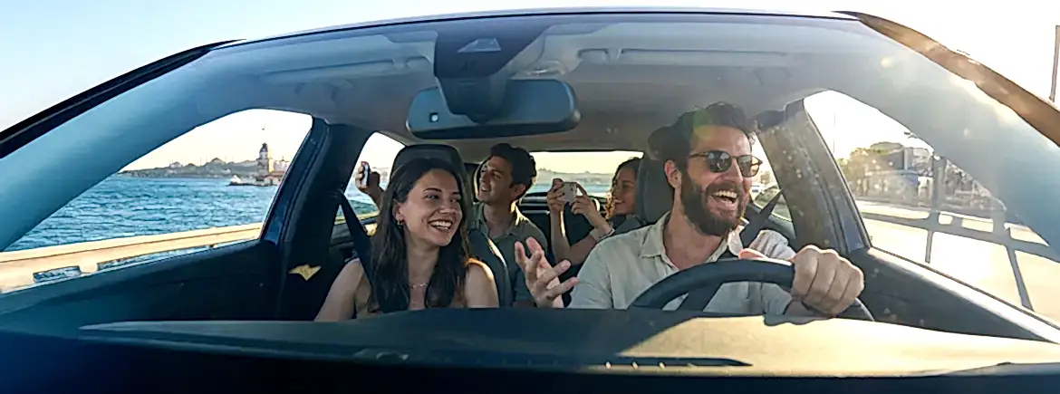 İstanbul sahil yolunda Kız Kulesi manzarası eşliğinde misafirlerini gezdiren neşeli sürücü ve şehir turları için ideal TikTak ile günlük araç kiralama konforu.